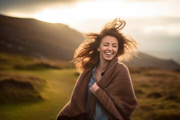 Portrait of a happy young woman with wind blowing her hair in the countryside