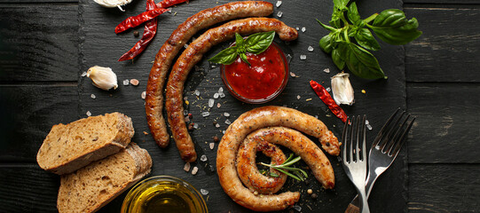 Flat lay composition with fried sausages on black table