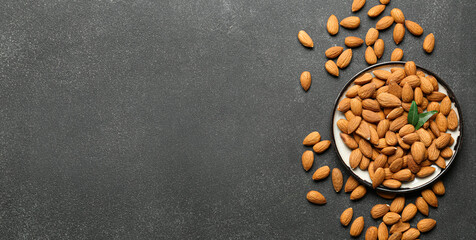 Plate of healthy almonds on dark background with space for text