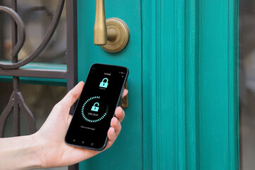 Woman unlocking door using mobile phone, closeup. Illustration of closed and open padlocks on...