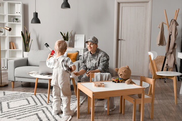 Little boy with toy and his military mother at home