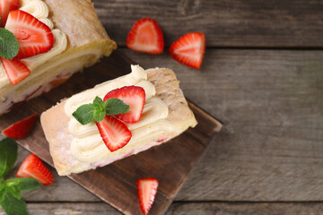 Pieces of delicious cake roll with strawberries and cream on table, top view. Space for text
