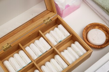 Fototapeta na wymiar Storage of tampons and different hygiene products in white drawer, closeup