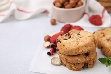 Cookies with freeze dried fruits, nuts and mint on white table, closeup. Space for text