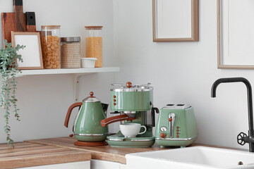 Electric kettle, toaster and coffee machine on wooden kitchen counter