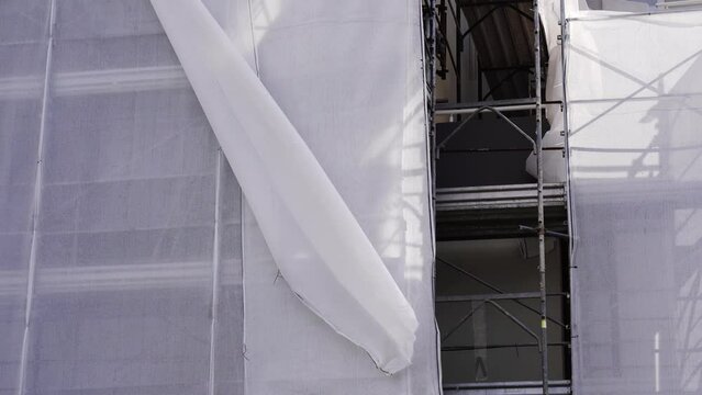 Downtown building scaffolding with torn off fabric sheet