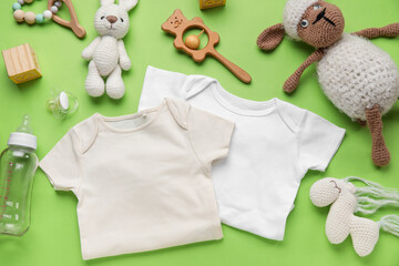 Composition with baby clothes and toys on light green background