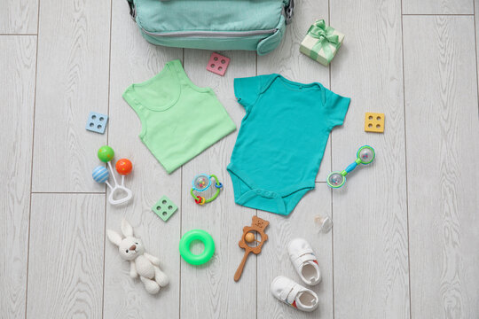 Stylish clothes and toys for baby on light wooden background - Powered by Adobe