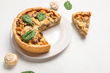 Mushroom pie with spinach leaves and champignons on white grunge table