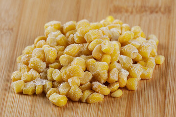 Close of Frozen Sweet Corn on a wooden chopping board