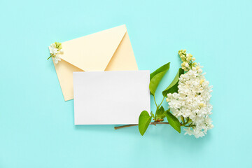 Envelope and blank card with lilac flowers on pale blue background