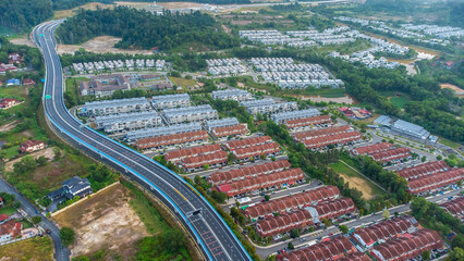 Aerial view of residential area with green asphalt road and residential houses directly above viewpoint. View of suburbs and city district. Real estate and housing market concept. - 601572557