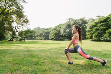 sports woman working out and stretching warm up leg muscle before outdoor running exercise in city park. outdoor fitness.