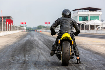 Man on motorbike on the road racing track riding, Biker sitting on motorcycle wearing helmet and...