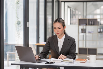 Young Asian businesswoman working on documents at office