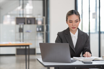Young Asian businesswoman working on documents at office