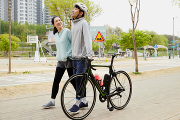 자전거를 끌고 산책하는 젊은 커플