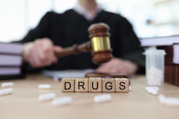 Word Drugs with cubes and scattered pills on judge counter
