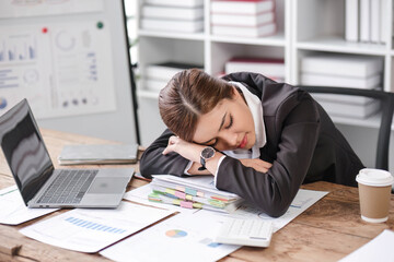 Asian businesswoman who is exhausted from work sleeping on the desk in the office.