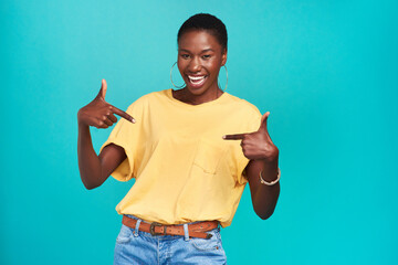 Portrait, crazy and pointing with a black woman in studio on a blue background looking carefree or...