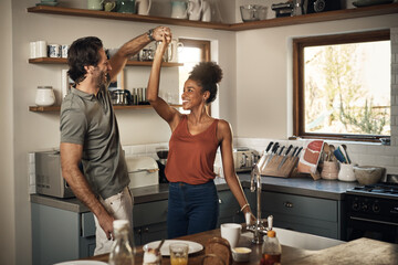 Happy couple, dance and fun bonding in kitchen for romance, love or holiday together at home. Interracial man and woman dancing in happiness for romantic relationship or enjoying weekend in the house - obrazy, fototapety, plakaty