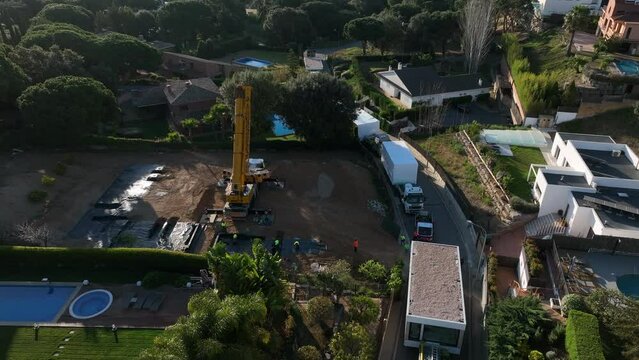 Work in progress on building site of modular home in residential area with luxury houses. Aerial top-down forward