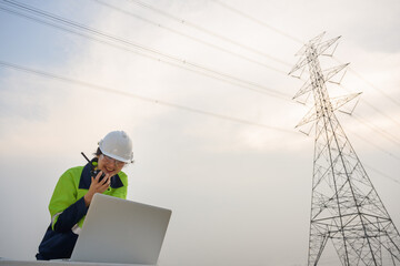 A picture of an woman electrical engineer Use a laptop computer to stand at the electricity station...