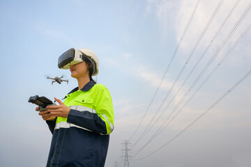 A picture of a female electrical engineers wearing VR headset (VR glasses) work at the electricity station. Flying drones to observe and see the electricity production plan at high voltage poles