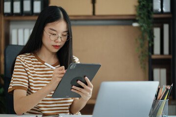 Fototapeta premium Send a message to a colleague, Female, confident in matching a tablet and sitting in home office.