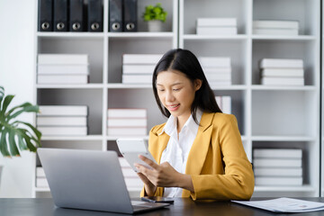 Businesswoman working with tablet and using a calculator to calculate the numbers of static in...