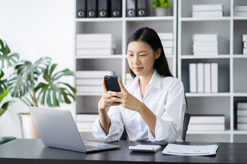 Businesswoman using mobile phone play social in home office.
