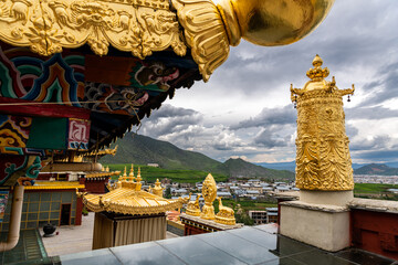 The golden praying decorations on the roof of Tibetan monastery (Shangri-La Songzanlin Monastery) at Shangri-la, Yunan, China. Dramatic sky, copy space for text