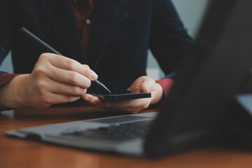 Corporate Communication. Asian Businesswoman Talking On Mobile Phone Working On Laptop In Modern Office. Free Space