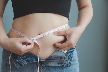fat woman, fat belly, chubby, obese woman hand holding excessive belly fat with measure tape, woman...