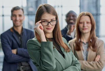 Obraz premium Portrait of a young serious business woman with colleagues