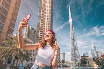 happy tourist asian girl taking selfie photos for her travel blog, in Dubai downtown - obrazy, fototapety, plakaty