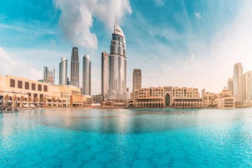 Zelfklevend Fotobehang Water pond near the entrance to Dubai Mall and on promenade embankment with skyscrapers in the background © EdNurg