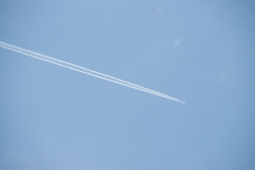 Airplane trail white against the blue sky