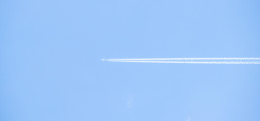 Airplane trail white against the blue sky