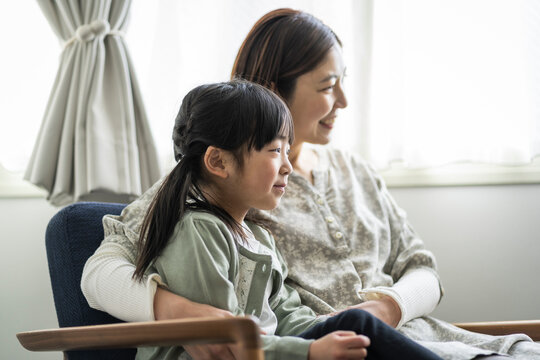 ソファーに座る日本人の母親と娘