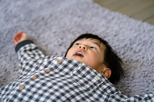 ラグの上に寝転ぶ日本人の男の子