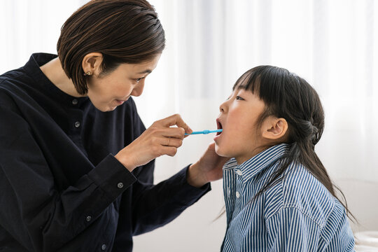 子供の歯磨きをする母親