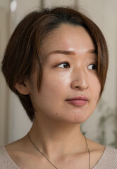 横を見るショートカットヘアの女性のアップ