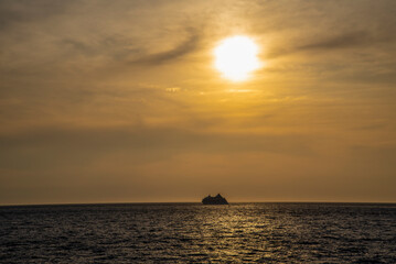 Fototapeta na wymiar A cruise ship sails into the sunset on a summer day.