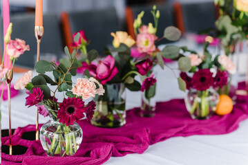 Decor details closeup. Decoration pink, flowers roses, chrysanthemum, carnation, candles for birthday party, wedding reception. Luxury elegant setting dinner in restaurant. Event, banquet.