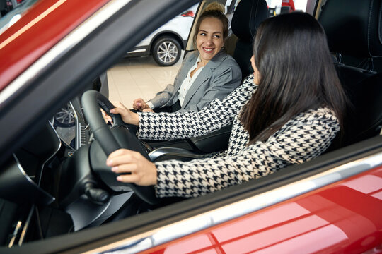 Two jojful businesswomen in a red car