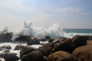 The black rocks at Jungle Beach hit by the wave with huge splashes, Unawatuna, Sri Lanka, baackground, copy space for text