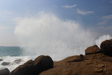 The black rocks at Jungle Beach hit by the wave with huge splashes, Unawatuna, Sri Lanka, baackground, copy space for text