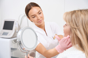 Obraz premium Doctor cosmetologist consults a client of an aesthetic medicine clinic