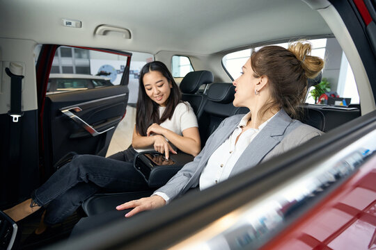 Two happy women at back seats in car